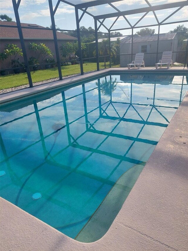 view of swimming pool featuring glass enclosure