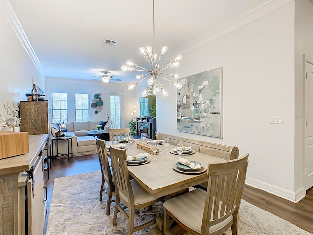 dining room with crown molding, dark wood-type flooring, and ceiling fan with notable chandelier