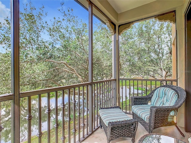 sunroom / solarium featuring a water view