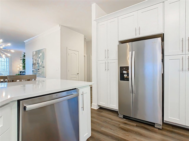 kitchen featuring appliances with stainless steel finishes, white cabinetry, ornamental molding, and dark wood-type flooring