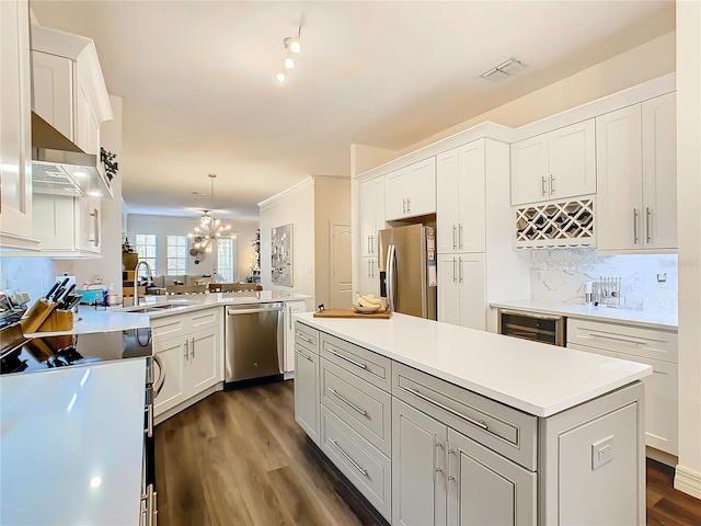 kitchen featuring kitchen peninsula, pendant lighting, stainless steel appliances, and white cabinets