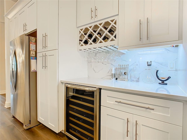 bar featuring white cabinets, stainless steel fridge, beverage cooler, and light hardwood / wood-style flooring