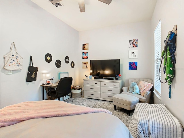 bedroom featuring ceiling fan, light colored carpet, and multiple windows