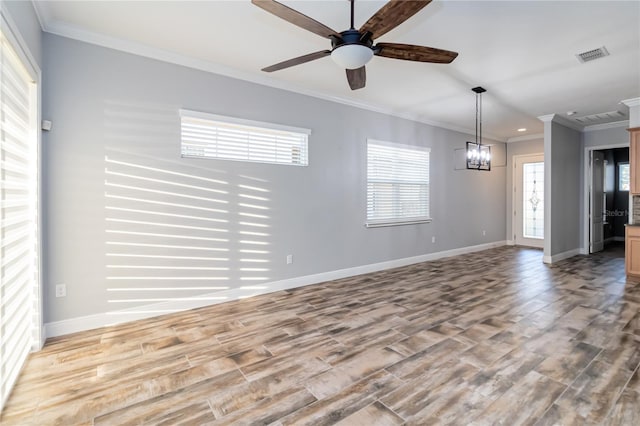 interior space with ceiling fan with notable chandelier, ornamental molding, and light hardwood / wood-style flooring