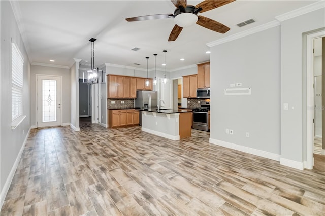 kitchen featuring appliances with stainless steel finishes, tasteful backsplash, light hardwood / wood-style floors, a kitchen island, and hanging light fixtures