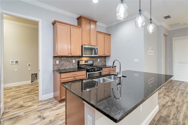 kitchen with decorative light fixtures, stainless steel appliances, a kitchen island with sink, and ornamental molding