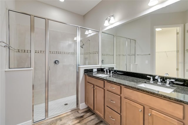 bathroom featuring wood-type flooring, vanity, and walk in shower