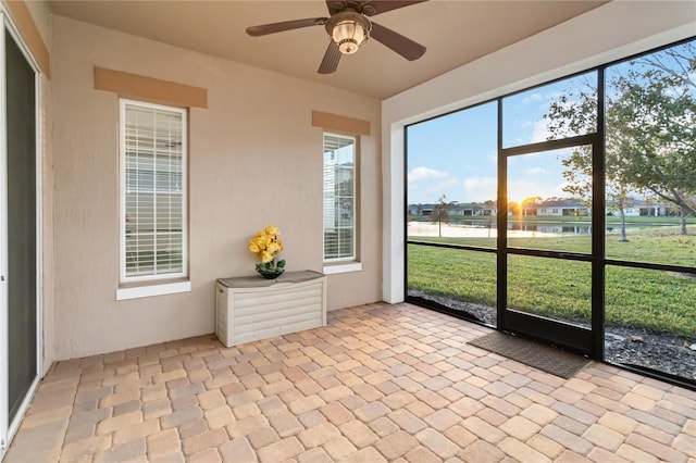 unfurnished sunroom with ceiling fan