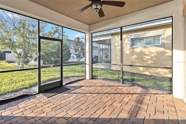 unfurnished sunroom with ceiling fan