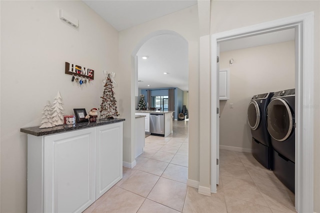 hallway with washer and dryer and light tile patterned flooring