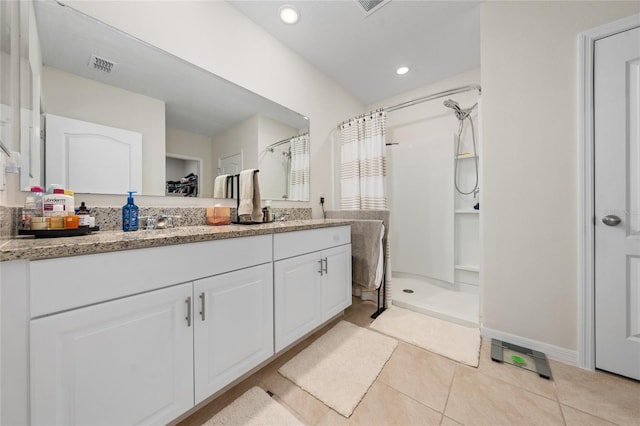 bathroom featuring vanity, tile patterned floors, and walk in shower