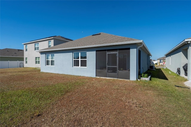 rear view of property with a sunroom and a yard