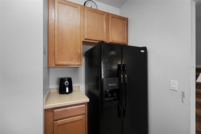 kitchen featuring black fridge with ice dispenser