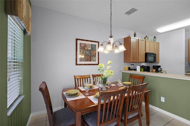 tiled dining space with a notable chandelier and a textured ceiling