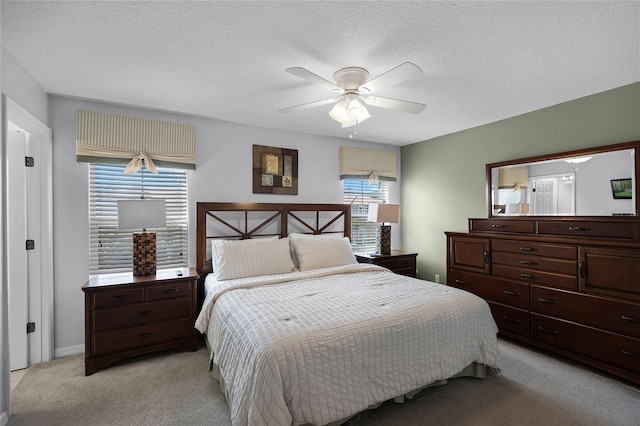 carpeted bedroom featuring ceiling fan and a textured ceiling