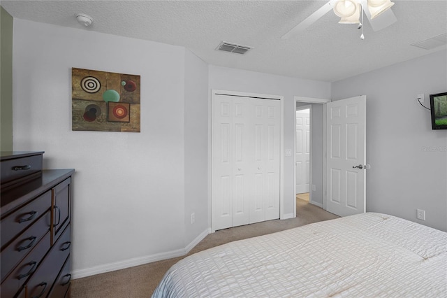 bedroom featuring carpet flooring, ceiling fan, a closet, and a textured ceiling