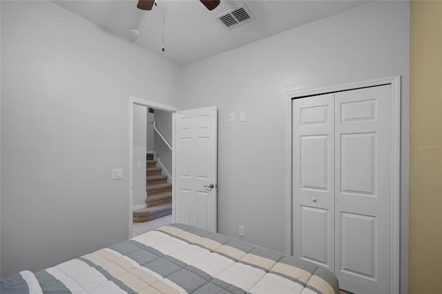 unfurnished bedroom with a textured ceiling, a closet, and ceiling fan