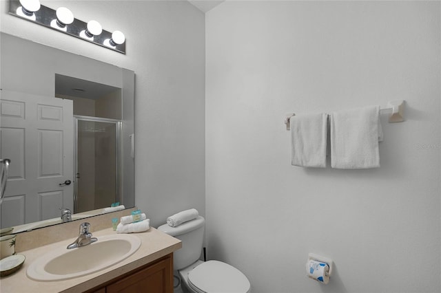 bathroom with vanity, toilet, and a shower with shower door