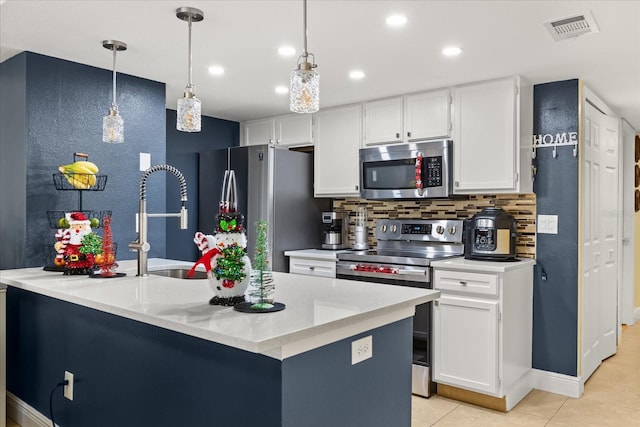 kitchen featuring backsplash, stainless steel appliances, pendant lighting, light tile patterned floors, and white cabinetry