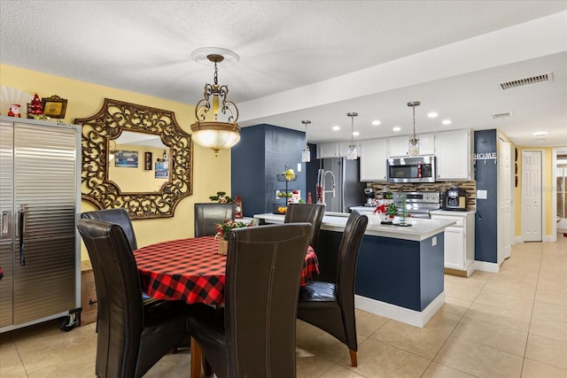 tiled dining space featuring a textured ceiling