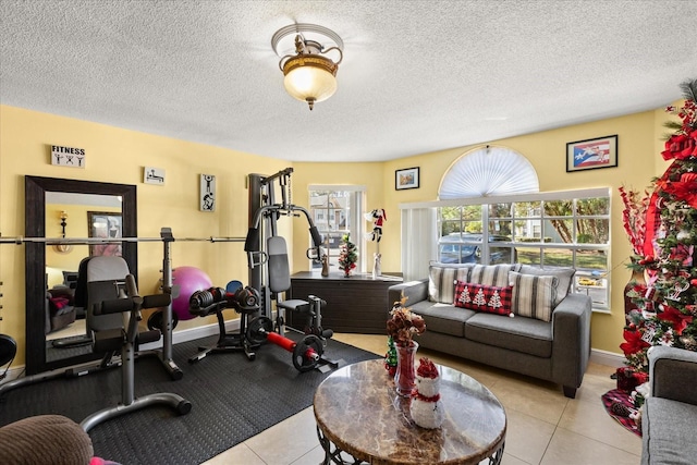 exercise area with light tile patterned floors and a textured ceiling