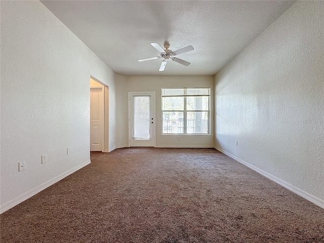 carpeted empty room with ceiling fan and a textured ceiling