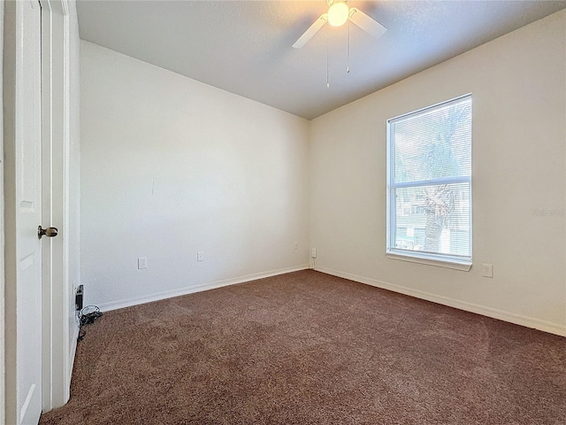 unfurnished room featuring dark colored carpet and ceiling fan