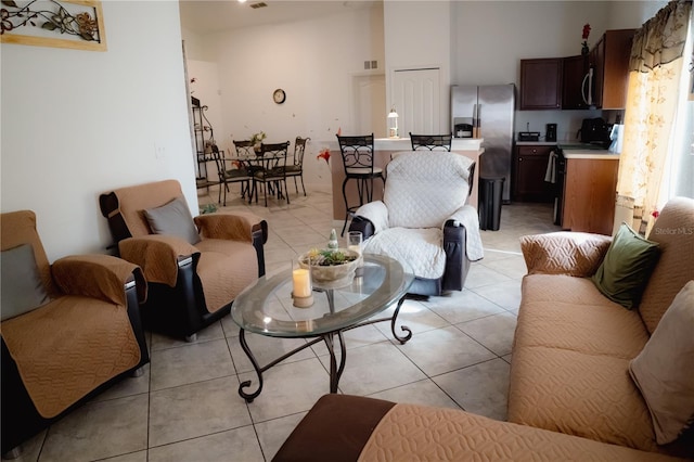 living room featuring light tile patterned floors and a high ceiling