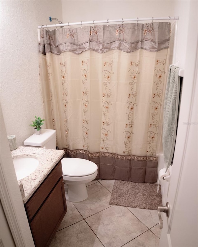 bathroom with tile patterned flooring, vanity, toilet, and a shower with curtain