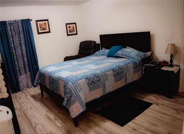 bedroom featuring light hardwood / wood-style floors and vaulted ceiling
