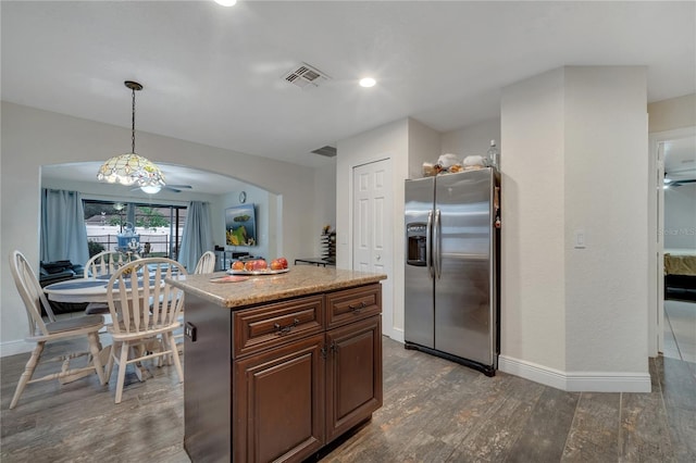 kitchen featuring pendant lighting, dark hardwood / wood-style flooring, a center island, dark brown cabinetry, and stainless steel refrigerator with ice dispenser