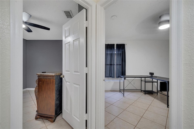 interior space featuring light tile patterned floors and a textured ceiling