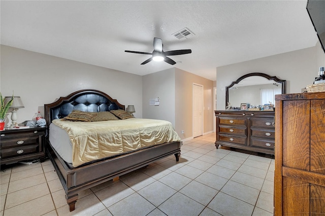 bedroom featuring ceiling fan, a textured ceiling, and light tile patterned floors