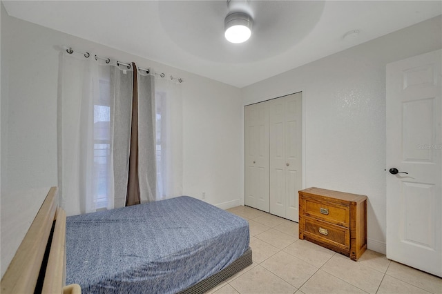 bedroom featuring light tile patterned floors, a closet, and ceiling fan