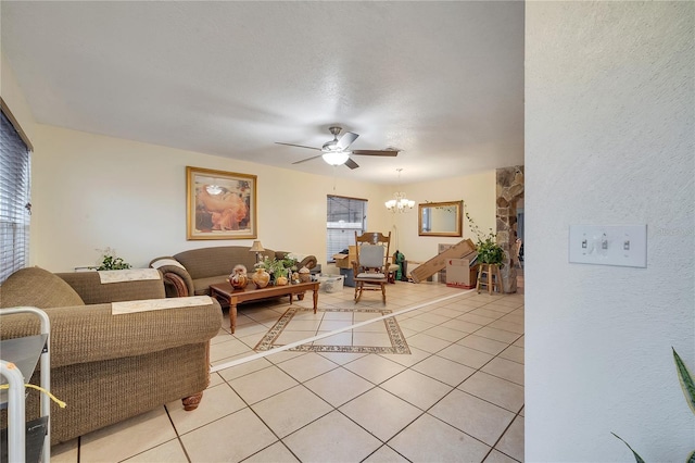 living room with a healthy amount of sunlight, ceiling fan with notable chandelier, and light tile patterned floors