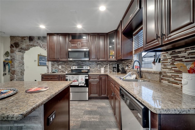 kitchen featuring dark brown cabinetry, sink, decorative backsplash, and appliances with stainless steel finishes