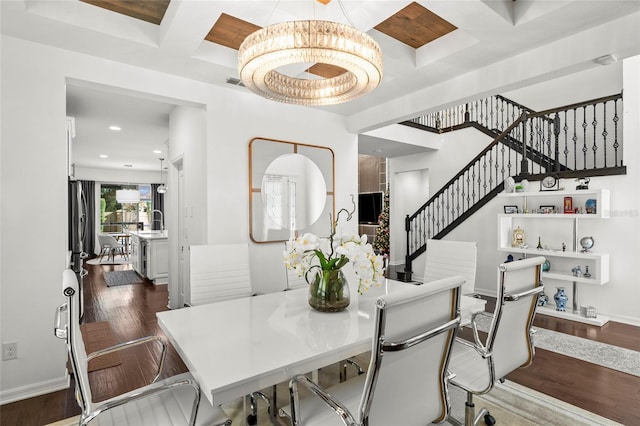 dining room featuring coffered ceiling, dark wood-type flooring, beamed ceiling, and an inviting chandelier