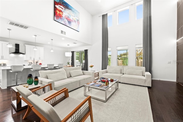 living room featuring wood-type flooring and a towering ceiling