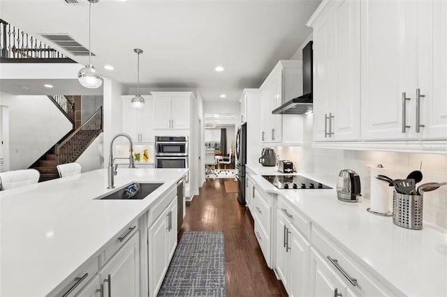 kitchen with white cabinetry, sink, wall chimney exhaust hood, dark wood-type flooring, and stainless steel appliances