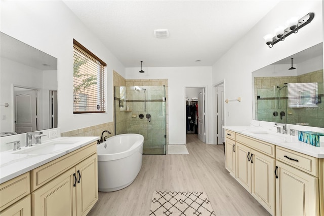 bathroom with hardwood / wood-style floors, vanity, and independent shower and bath