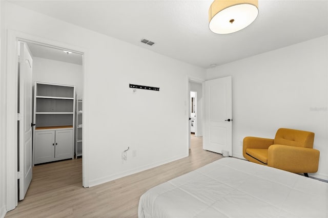 bedroom with a closet, a spacious closet, and light hardwood / wood-style flooring