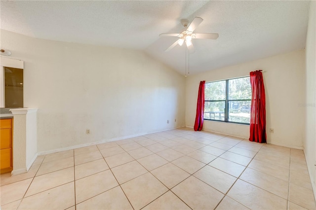 tiled spare room featuring ceiling fan, lofted ceiling, and a textured ceiling