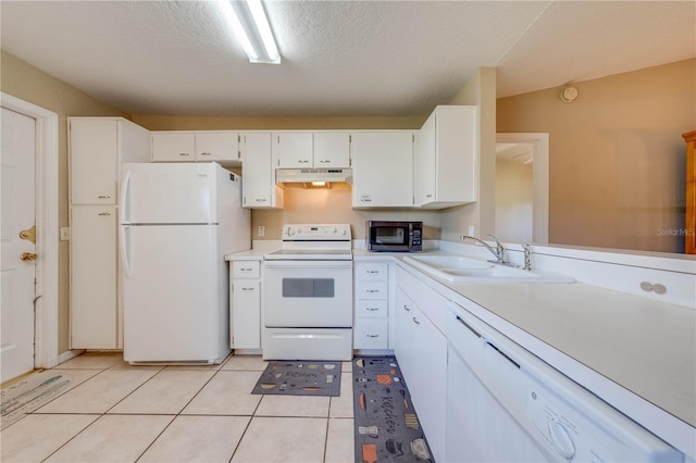 kitchen featuring white appliances, sink, vaulted ceiling, light tile patterned flooring, and white cabinetry