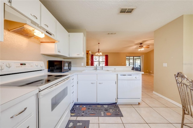 kitchen featuring white appliances, white cabinets, sink, decorative light fixtures, and kitchen peninsula