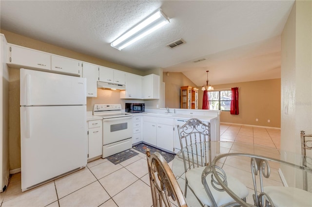 kitchen with pendant lighting, lofted ceiling, white appliances, white cabinets, and a notable chandelier