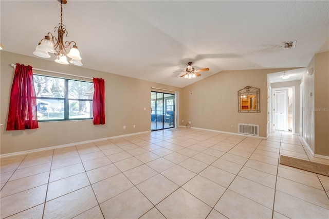 empty room with plenty of natural light, lofted ceiling, ceiling fan with notable chandelier, and light tile patterned floors