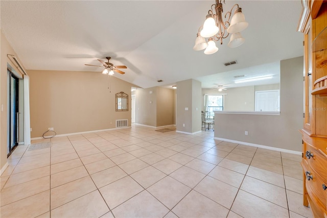 spare room with light tile patterned floors, ceiling fan with notable chandelier, and vaulted ceiling