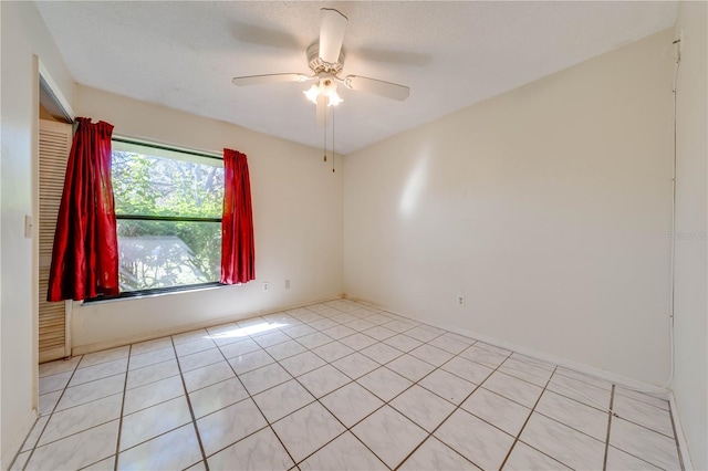 spare room with light tile patterned floors, a textured ceiling, and ceiling fan