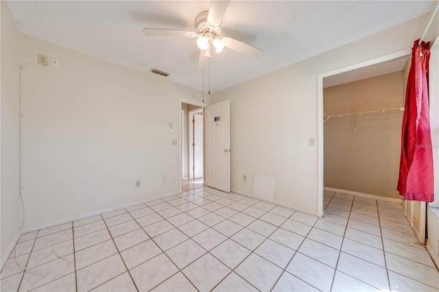 unfurnished bedroom with ceiling fan, a closet, light tile patterned floors, and a spacious closet