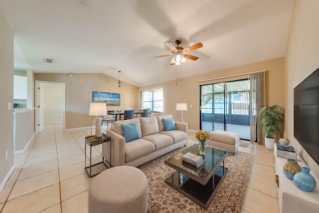 living room with ceiling fan, light tile patterned floors, and vaulted ceiling